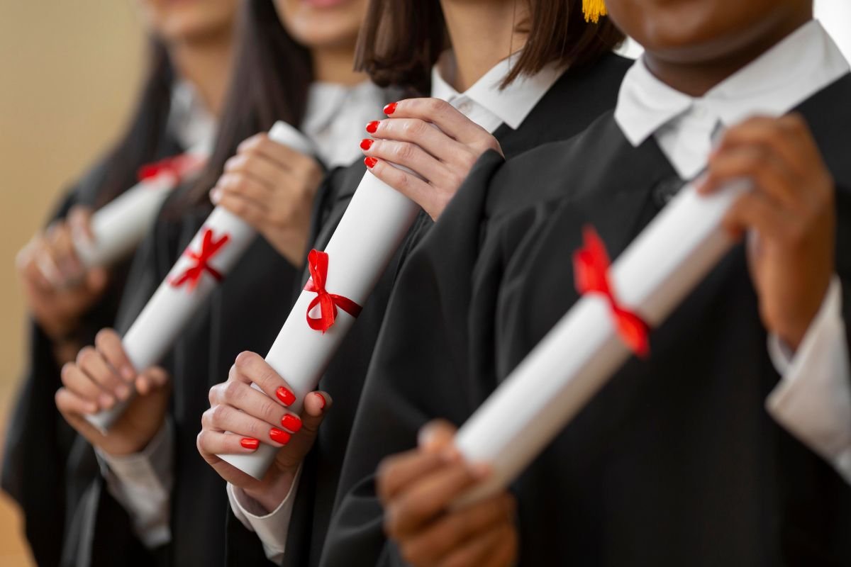 pessoas segurando diplonas com as becas.