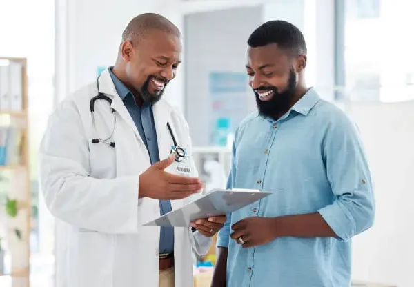 Homem recebendo informações de médico em consultório