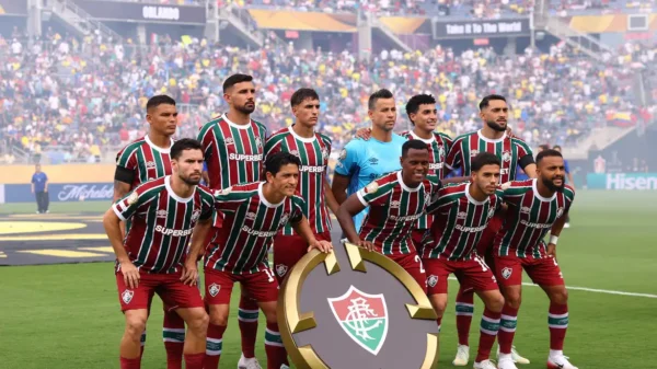 Jogadores do Fluminense posam para foto em campo, segurando o escudo do time, no Mundial de Clubes da FIFA 2025.