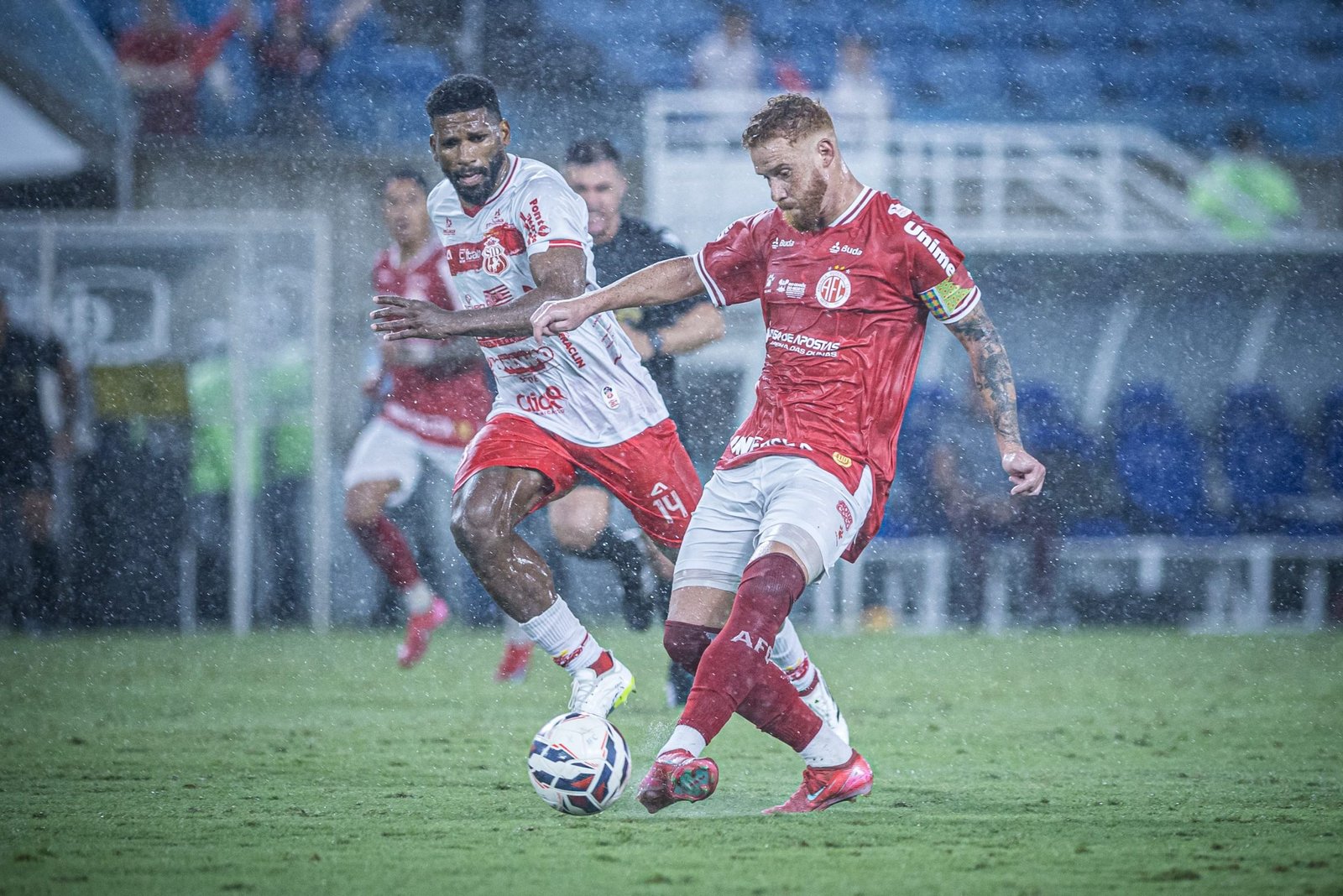 Jogador do América e Imperatriz jogando com forte chuva na Arena das Dunas.