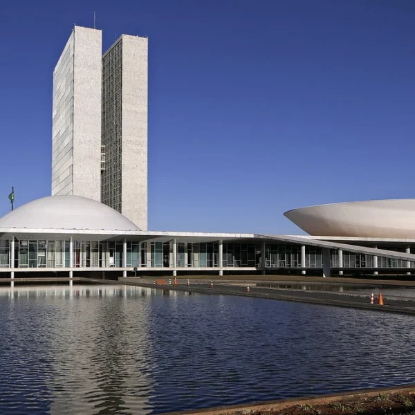 Congresso Nacional refletido no espelho d’água em Brasília, símbolo do poder legislativo que retoma atividades com foco no IR e apostas online