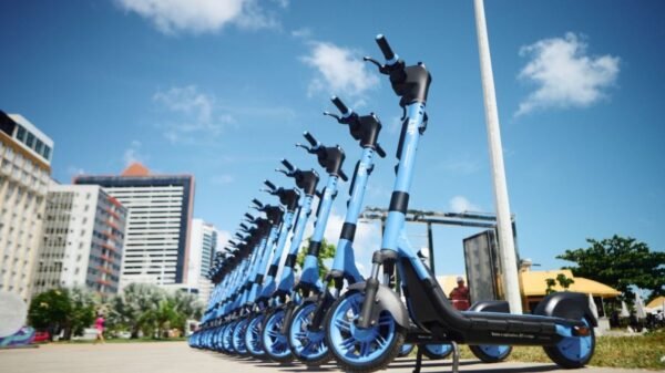 patinetes azuis expostos enfileirados para a população utilizar.