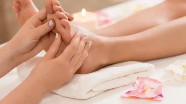 imagem de um pé sendo massageado numa maca,