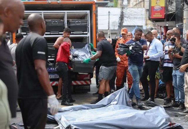 Pessoas colocando os corpos das pessoas mortas na megaoperação, no carro do IML.