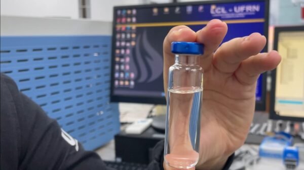 Pesquisador segurando uma amostra de bebida.