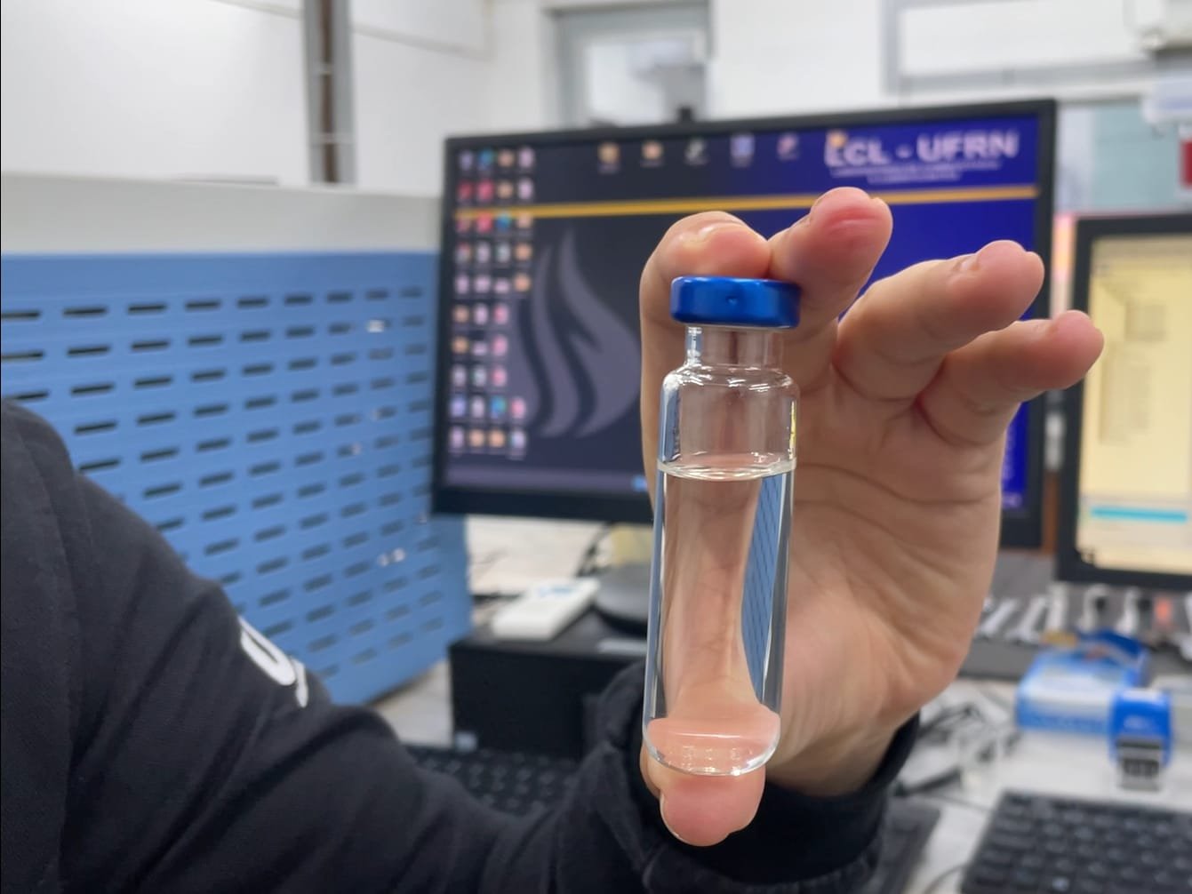 Pesquisador segurando uma amostra de bebida.