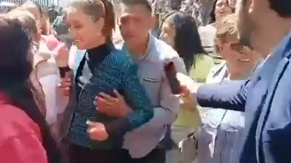 Foto da presidente Claudia Sheinbaum em evento público, cercada por apoiadores sendo assediada por um homem.
