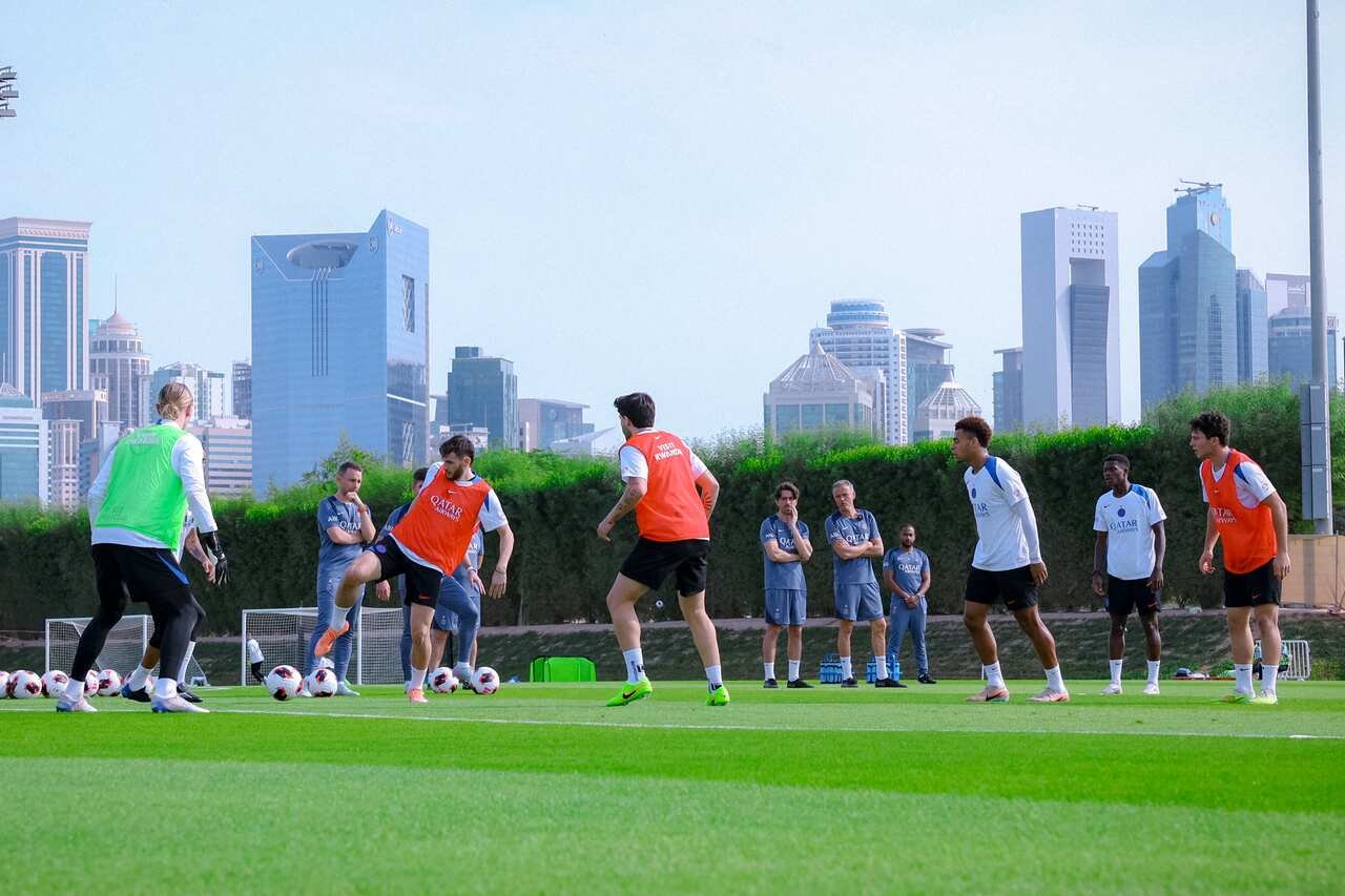 Jogadores do PSG treinando no campo.