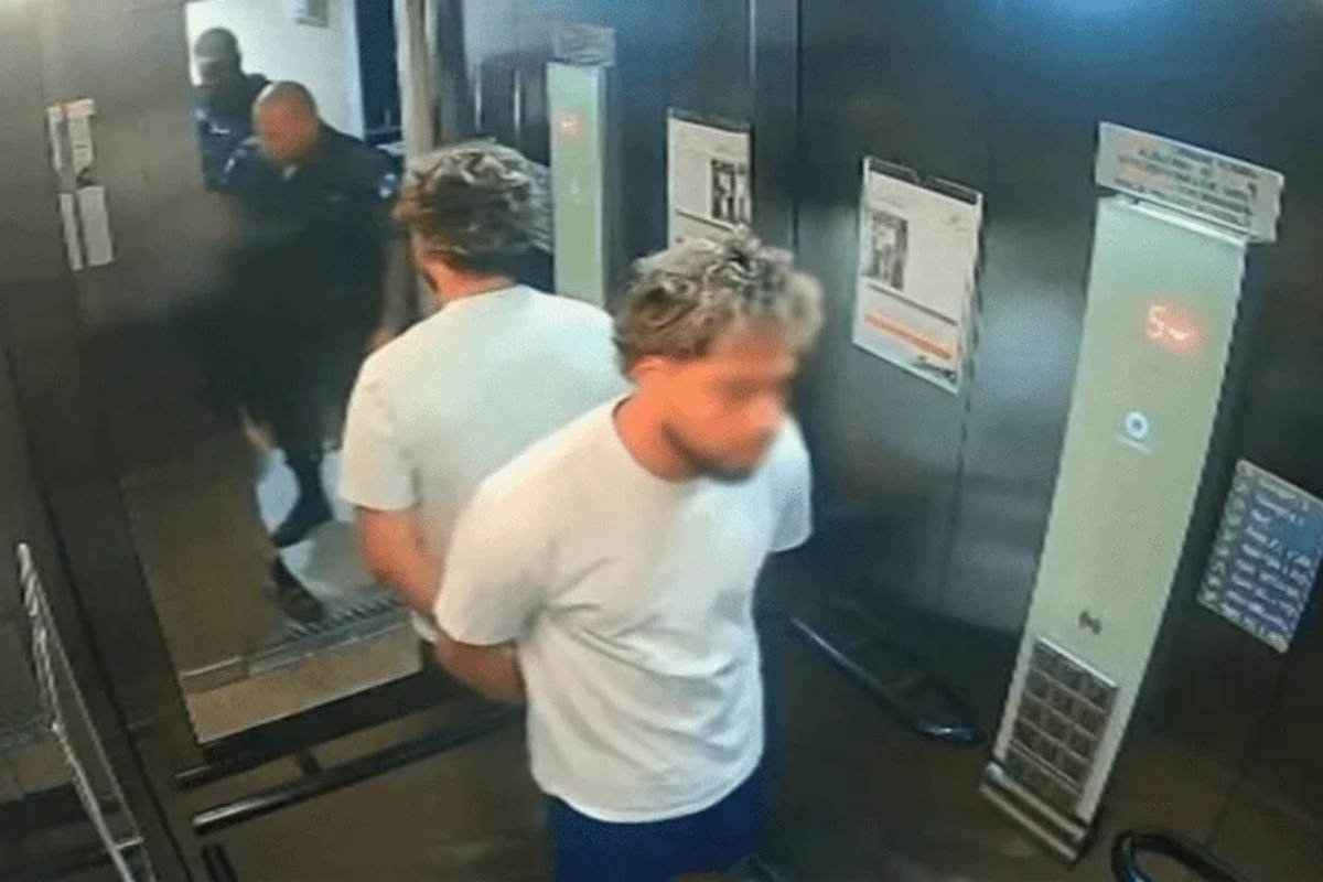 Eric Christian Hernandez virou réu após agredir a namorada em elevador de prédio em Botafogo, RJ. Passaporte segue retido até conclusão da instrução.
