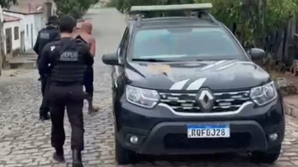 imagem da viatura da polícia civil com suspeito preso