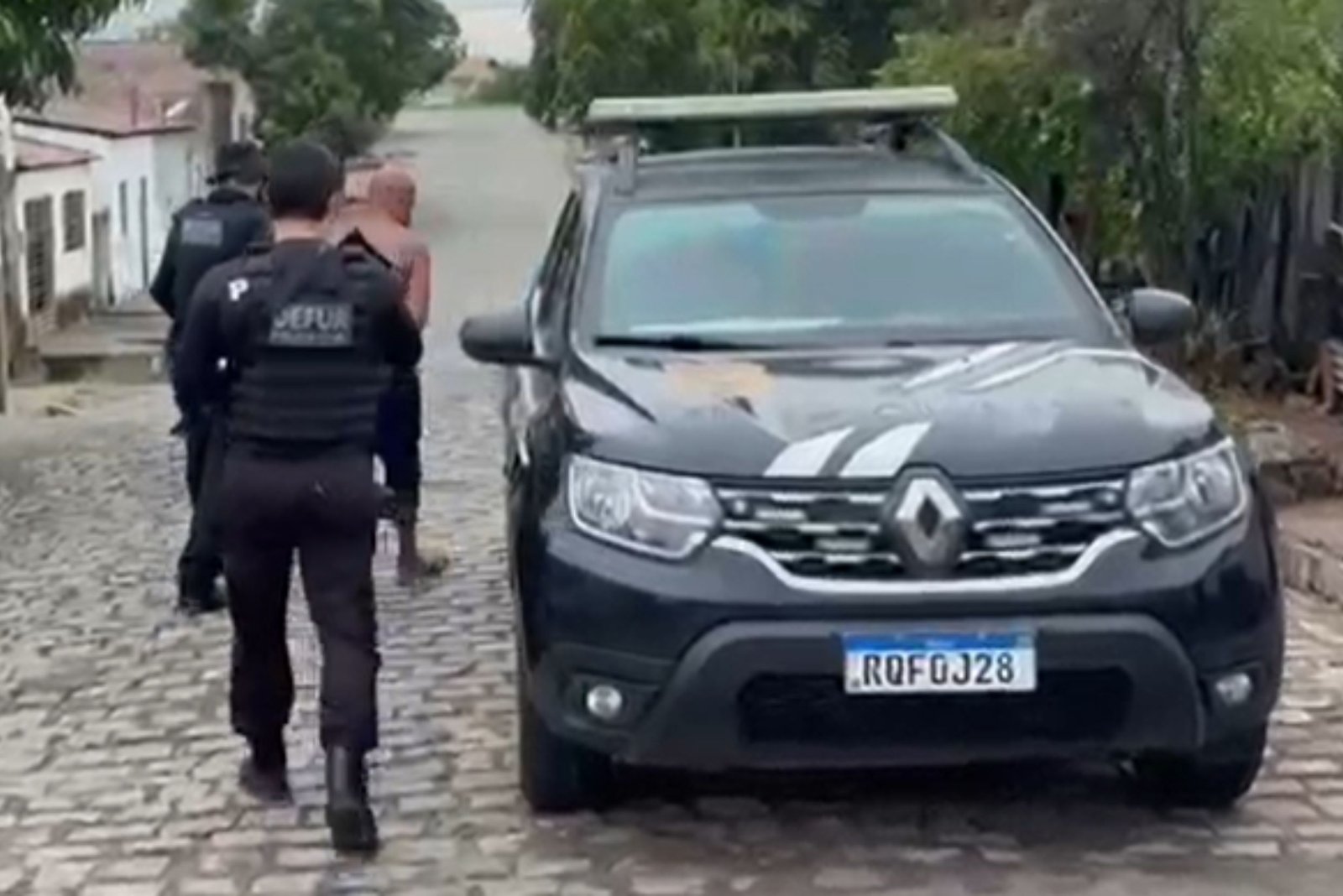 imagem da viatura da polícia civil com suspeito preso