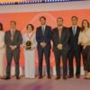Fabíola Almeida, diretora-presidente da Neoenergia Cosern, recebe o troféu de melhor Distribuidora de Energia do Brasil, acompanhada por executivos e colaboradores da companhia na cerimônia do Prêmio Abradee 2026, em Brasília.
