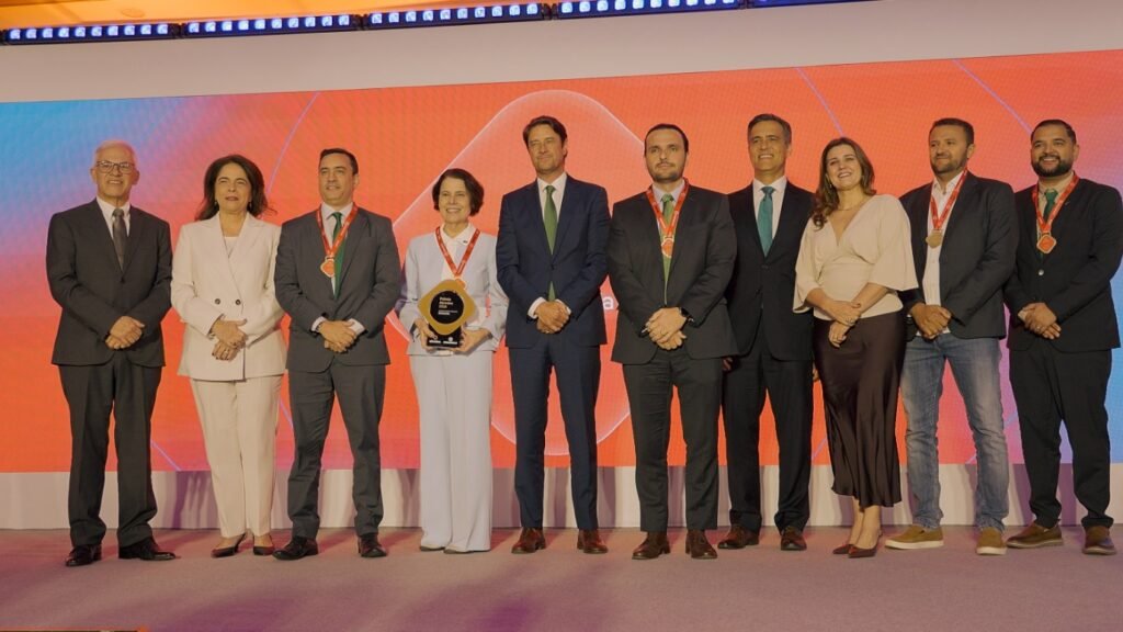 Fabíola Almeida, diretora-presidente da Neoenergia Cosern, recebe o troféu de melhor Distribuidora de Energia do Brasil, acompanhada por executivos e colaboradores da companhia na cerimônia do Prêmio Abradee 2026, em Brasília.