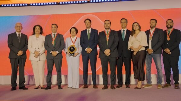 Fabíola Almeida, diretora-presidente da Neoenergia Cosern, recebe o troféu de melhor Distribuidora de Energia do Brasil, acompanhada por executivos e colaboradores da companhia na cerimônia do Prêmio Abradee 2026, em Brasília.