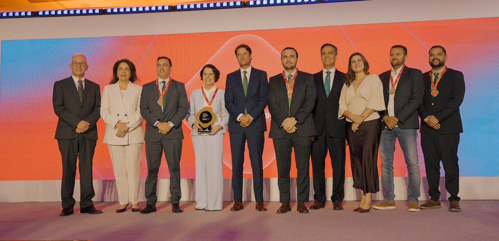 Fabíola Almeida, diretora-presidente da Neoenergia Cosern, recebe o troféu de melhor Distribuidora de Energia do Brasil, acompanhada por executivos e colaboradores da companhia na cerimônia do Prêmio Abradee 2026, em Brasília.